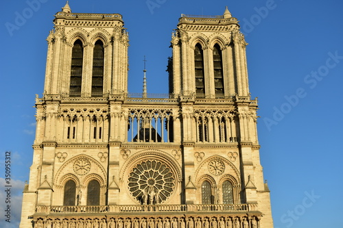 Notre-Dame de Paris Cathedral facade closeup at sunset with blue sky. Paris, France.