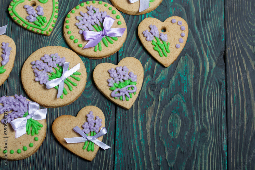 Gingerbread cookies decorated with glaze. On some ribbons tied to a bow. Gingerbread cookies are round and in the shape of a heart. On brushed pine boards. Gingerbread cookies decorated with glaze. On some ribbons tied to a bow. Gingerbread cookies are round and in the shape of a heart. On brushed pine boards.