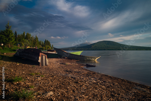 The view of the sunset and boats on the lake Zuratkul