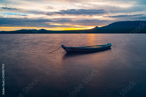 The view of the sunset and boats on the lake Zuratkul