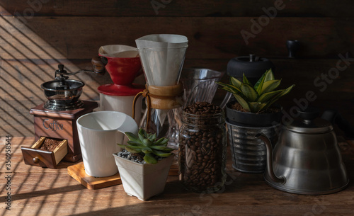 Coffe drip set with roasted beans kettle grinder white cup and flower pot on wood table and background