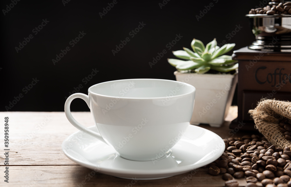 Steam coffee cup with grinder,roasted beans and flower pot on wood background in morning sunlight Steam coffee cup with grinder,roasted beans and flower pot on wood background in morning sunlight