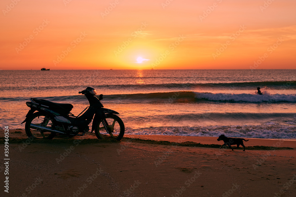 Fototapeta premium Biker on sunrise beach beautiful view