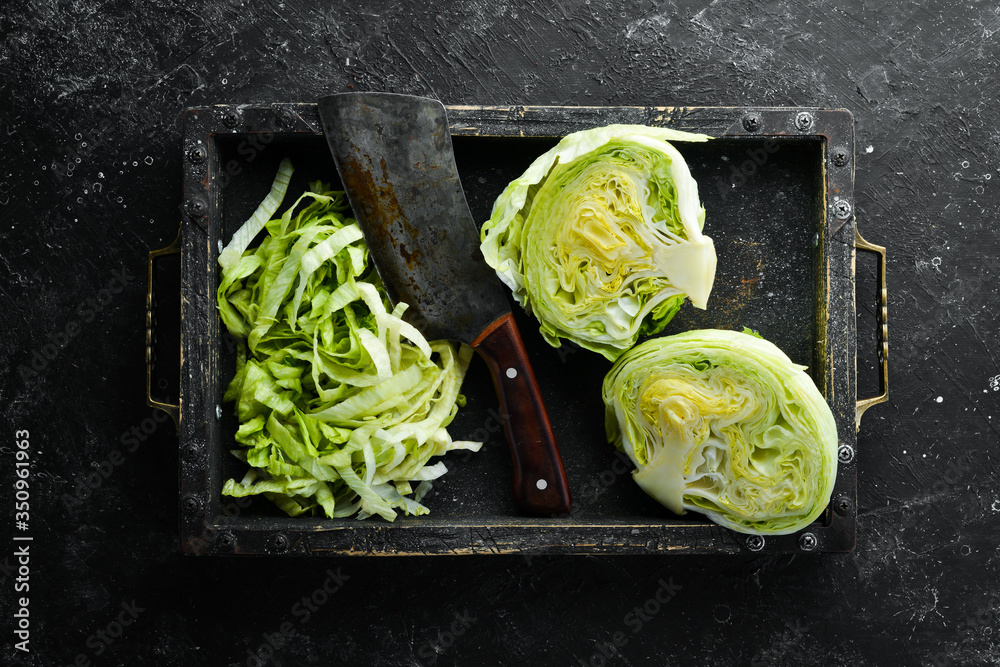 Iceberg lettuce in a wooden box. Top view. Free copy space. - obrazy, fototapety, plakaty 