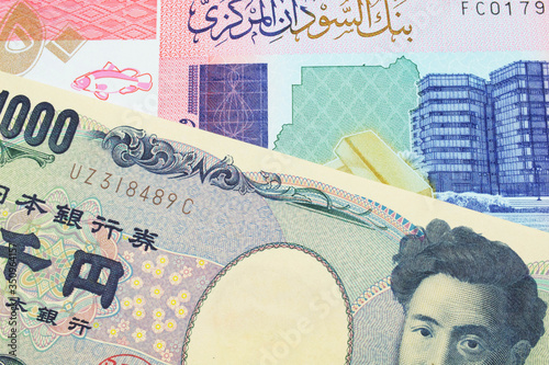 A macro image of a Japanese thousand yen note paired up with a colorful fifty pound bank note from Sudan. Shot close up in macro.