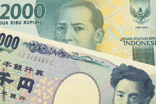 A macro image of a Japanese thousand yen note paired up with a grey two thousand rupiah bank note from Indonesia. Shot close up in macro.