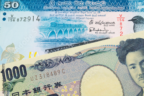 A macro image of a Japanese thousand yen note paired up with a blue and white fifty rupee bank note from Sri Lanka. Shot close up in macro.