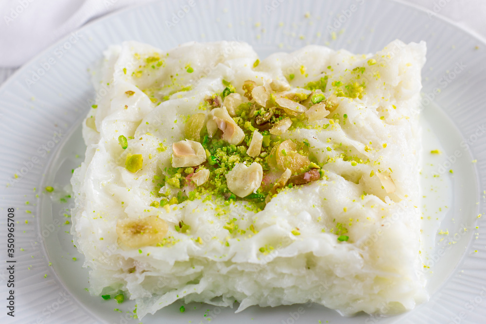 Traditional turkish meal - Gullac. Milk dessert sprinkled with ground nuts and pistachios Traditional turkish meal - Gullac. Milk dessert sprinkled with ground nuts and pistachios