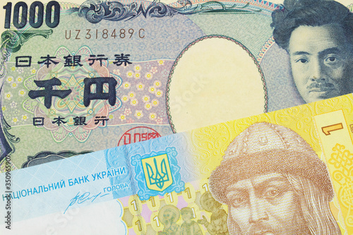 A macro image of a Japanese thousand yen note paired up with a blue, white and yellow one hyrvnia bank note from Ukraine. Shot close up in macro.