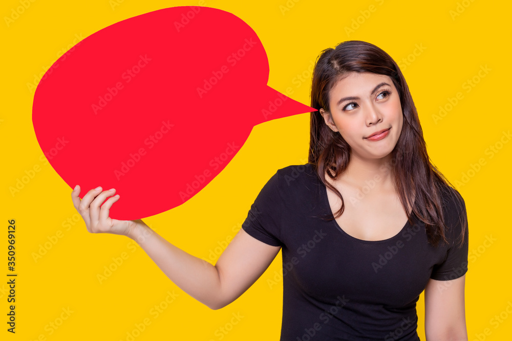 Asian woman hold bubble speech. Pretty Asia girl thinking for shopping, act like a decide in head that she should buy her favorite thing. Attractive beautiful young female portrait. yellow background Asian woman hold bubble speech. Pretty Asia girl thinking for shopping, act like a decide in head that she should buy her favorite thing. Attractive beautiful young female portrait. yellow background