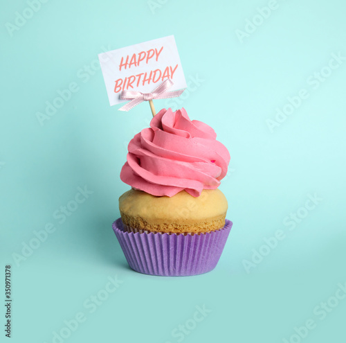 Beautiful birthday cupcake on light blue background