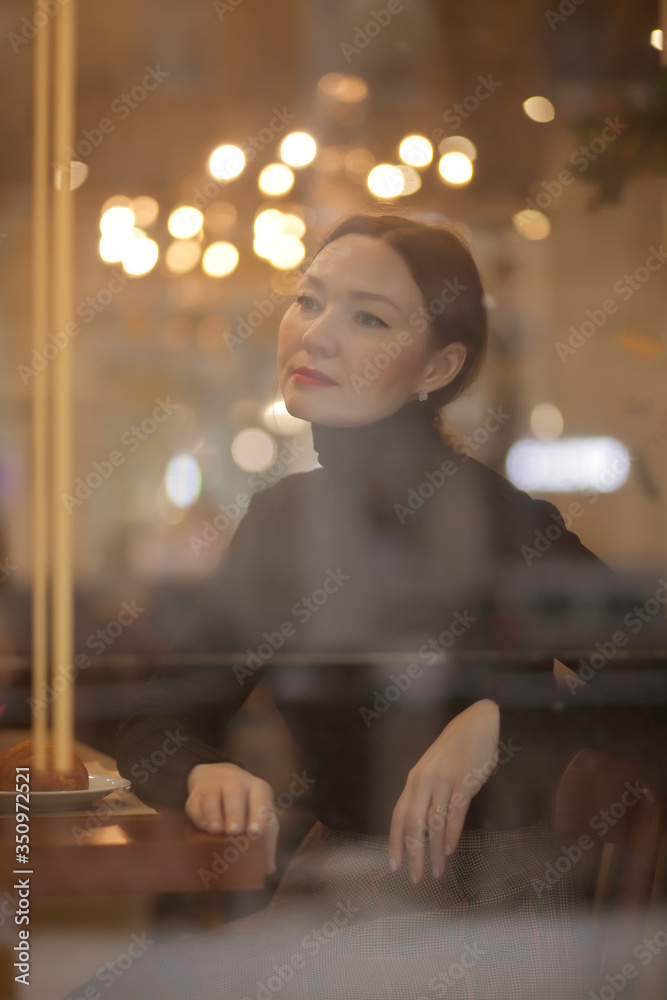 Beauty adult dreaming young woman looking through window at the coffee house restaurant