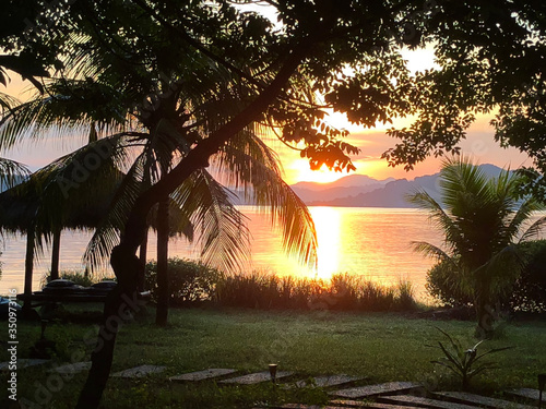 Bright colorful sunset over the sea, mountains on the horizon. Indonesia, view from Gili Asahan island photo