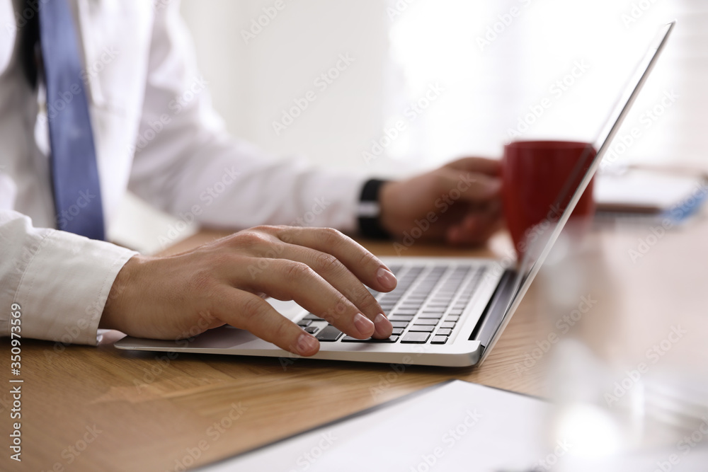 Man working with laptop in office, closeup of hand Man working with laptop in office, closeup of hand