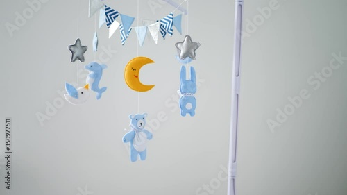 baby mobile with different animals hanging over the crib of a newborn baby in the bedroom on a white background