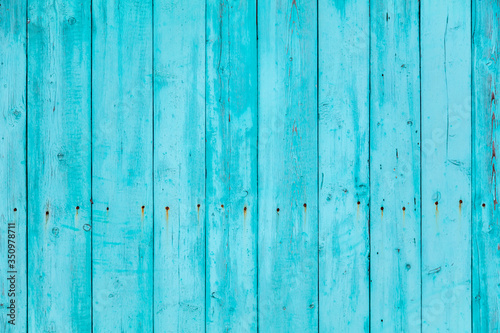 Wooden boards on an old blue fence as an abstract background.