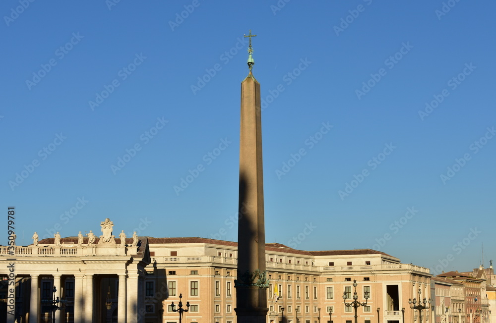 View of St. Peter’s Square with the egyptian Obelisk and blue sky at sunset. Vatican City, Rome, Italy.