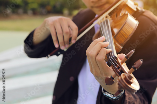 The hand of a musician who is playing violin happily