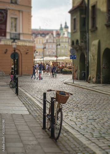 rower zaparkowany na brukowanej ulicy, stare miasto w tle