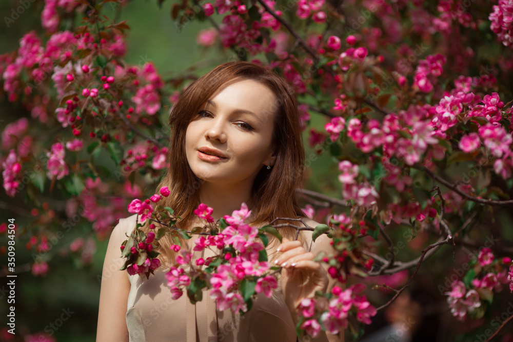 portrait of a beautiful young woman with make-up near a tree with flowers portrait of a beautiful young woman with make-up near a tree with flowers