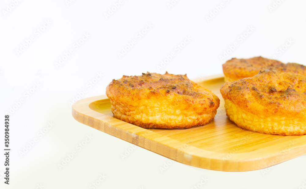 Wooden board with delicious rosy cupcakes on a white plate, top view. Wooden board with delicious rosy cupcakes on a white plate, top view.