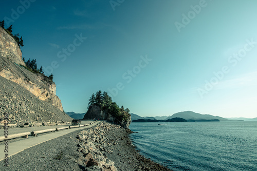 Breathtaking road from Icy Strait Point to Hoonah city, Alaska. Clear blue sky, sunny weather, beautiful calm sea. photo
