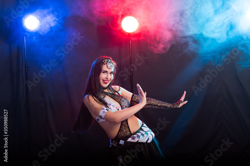 Portrait of a woman in oriental costume performing belly dance. Tribal fusion dance concept.