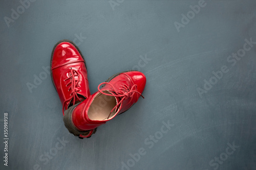 Fashion and style. Stylish women's red patent leather shoes on grey wooden background. Top view. Copy space.