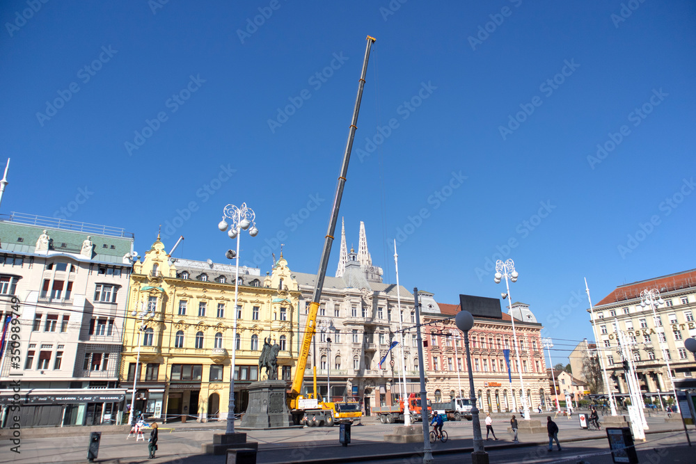 Croatia-April 6th, 2020: Building crane parked on the main Zagreb city square, preparing to remove debris and broken building parts damaged in strong earthquake that ruined south tower of cathedral