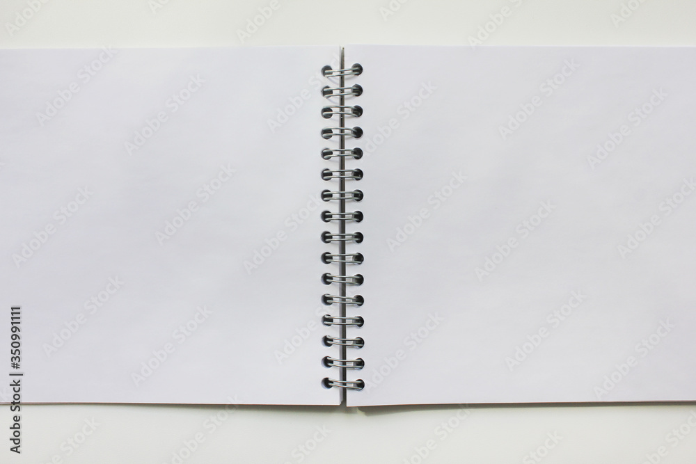 Spiral notebook with white pages. Blank spiral note book laying open on the table, dairy with empty pages for text. Education accessories, notepad or copybook with nothing written Spiral notebook with white pages. Blank spiral note book laying open on the table, dairy with empty pages for text. Education accessories, notepad or copybook with nothing written