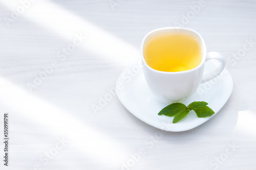 Fresh herbal mint tea on white wooden background. Flat lay, copy space.