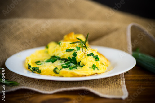 hot fried omelet with chopped green onions in a plate