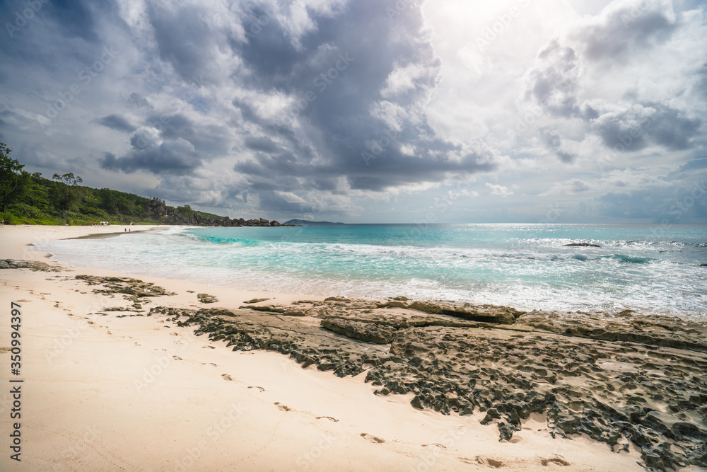 Grand Anse beach, Seychelles, La Digue, tropical sandy beach, blue ocean and rainy clouds
