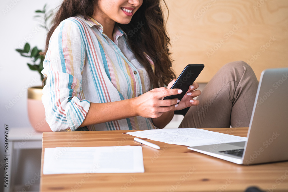 Unrecognizable smiling woman using mobile phone at home stock photo Unrecognizable smiling woman using mobile phone at home stock photo