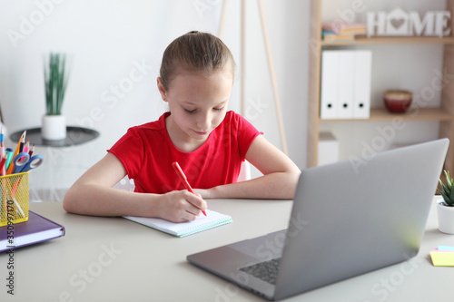 A child learns online at home through a modern laptop on the Internet.
