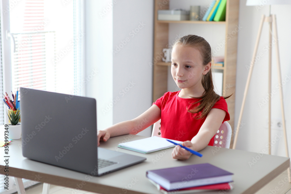A child learns online at home through a modern laptop on the Internet.
A child learns online at home through a modern laptop on the Internet.