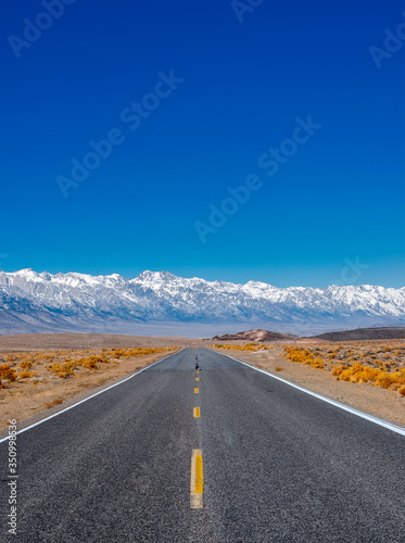 The road intersects the plain and rests against the mountains.