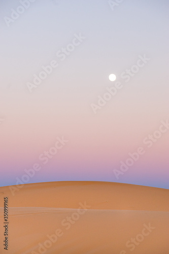 desert light at dusk with orange color and purple with full moon
