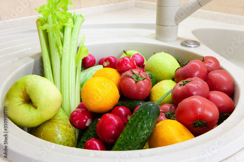 Washing fruits and vegetables in sink after shopping from grocery store during Coronavirus Covid-19 quarantine period. Concept of safety  precautions  reinsurance during pandemic