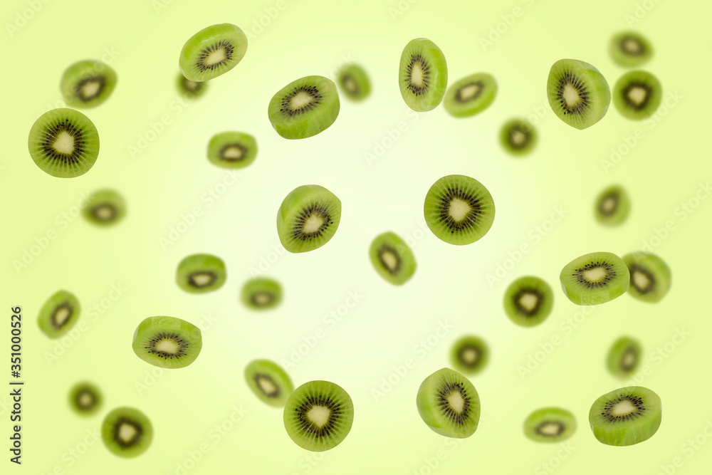 Falling kiwi slices isolated on a green background with clipping path as package design element and advertising.