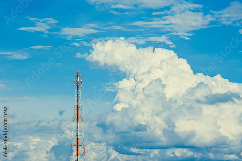 Telecommunication tower with beautiful blue sky with clouds. Anime sky clouds, anime style. Dramatic white clouds and sunlight. Sky background for animation or designer.