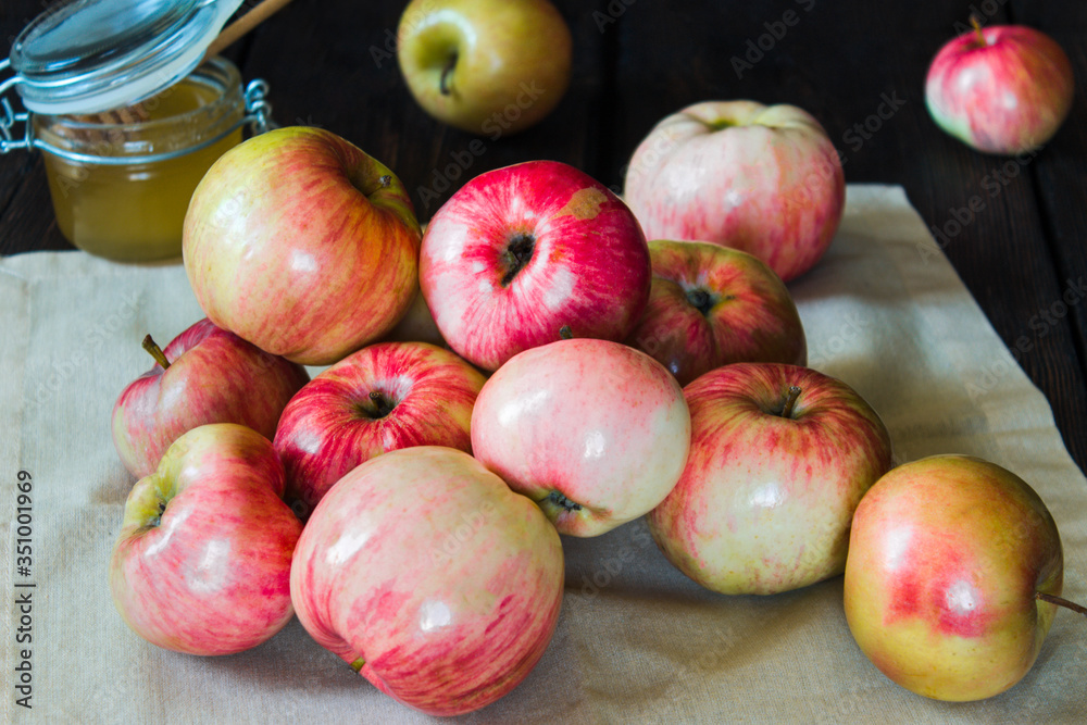 Apples in a basket and honey on a black background. Apples in a basket and honey on a black background.