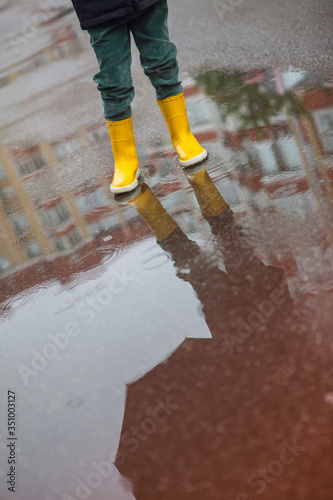 Boy in yellow boots in the rain