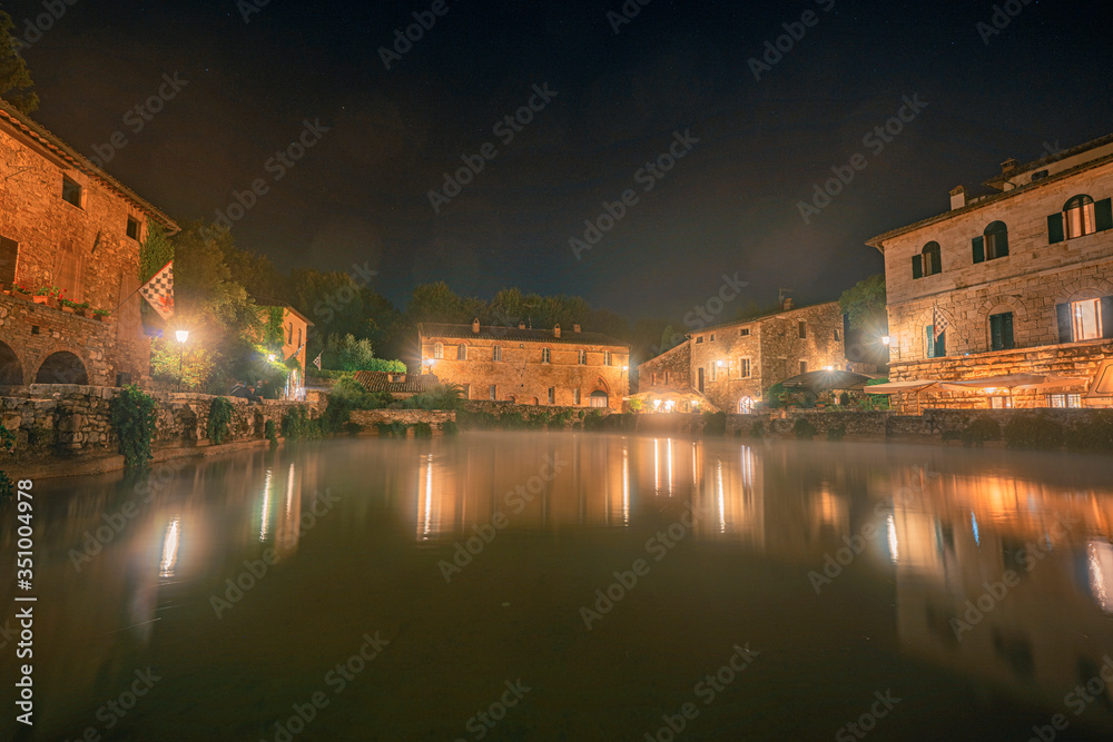 Central square with the thermal pool in old town Bagno Vignoni at night. Tuscany, Italy