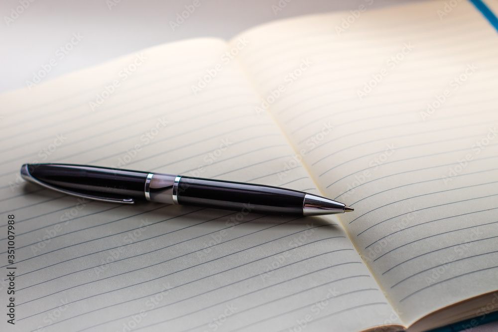 dark pen and notepad on the table dark pen and notepad on the table