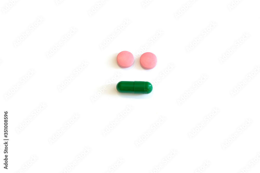 Colored round pills on a white background with copy space in the form of a smiley Colored round pills on a white background with copy space in the form of a smiley