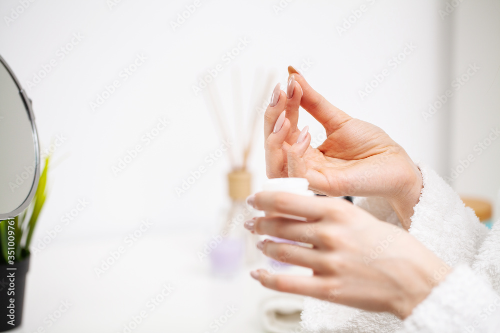 Naklejka premium Woman close up holding moisturizer for skin care
