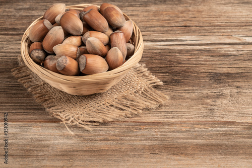 closeup hazelnuts in a basket on wooden table