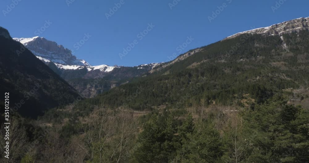 Looking up mountainous valley towards snow covered peaks Looking up mountainous valley towards snow covered peaks