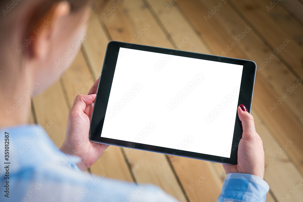 Woman sitting and looking at digital tablet computer device with white blank screen. Mock up, entertainment, copyspace, template, leisure time and technology concept